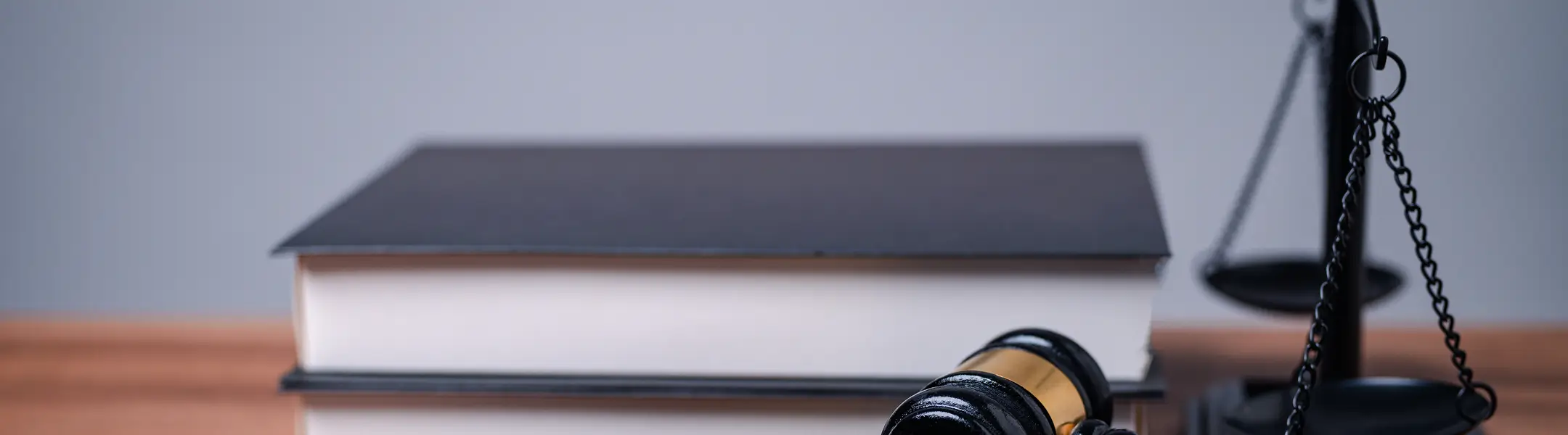 Gavel, law books, and scales of justice on a wooden desk